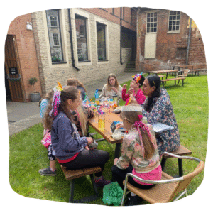 Colour photo of The Lost Flock performers stting at a bench and eating lunch