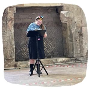 Colour photo of young person narrating from a stand