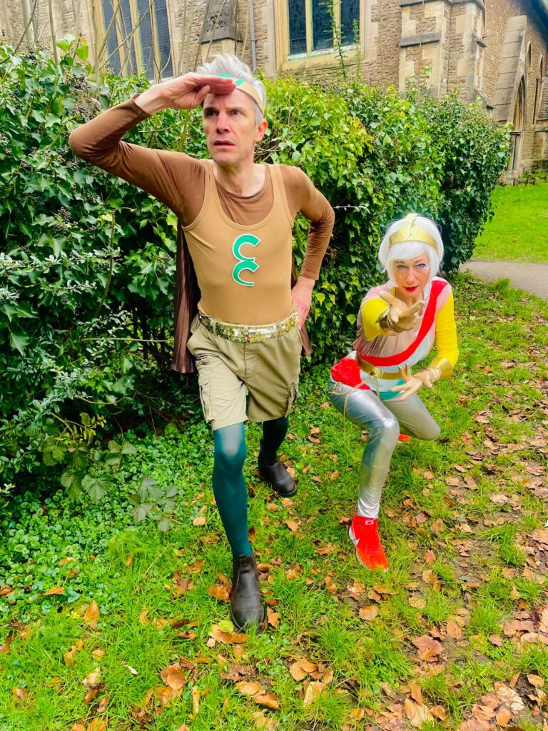 Photo of Captain Compost and Windy Gale - facilitators wearing colourful outfits and doing super hero poses.